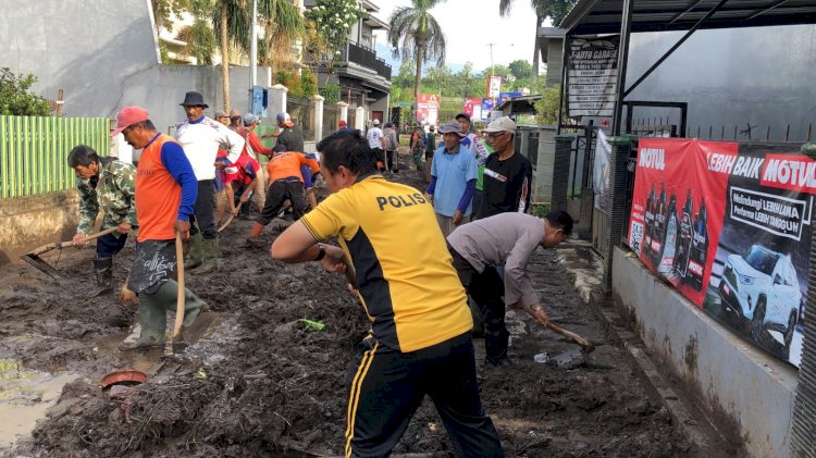 Sinergitas Polres Batu Bersama TNI dan Warga Bersihkan Lumpur Akibat Banjir Lalulintas Kembali Lancar